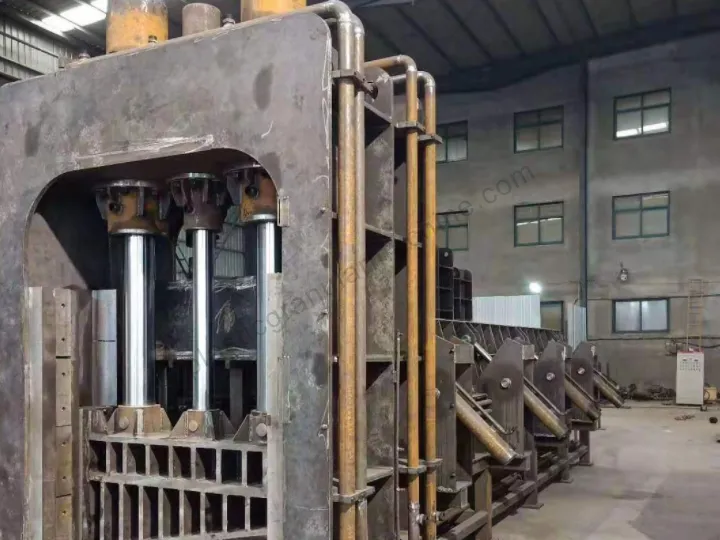 close-up of the main hydraulic cylinders and high-pressure pipes on a heavy-duty hydraulic gantry shear